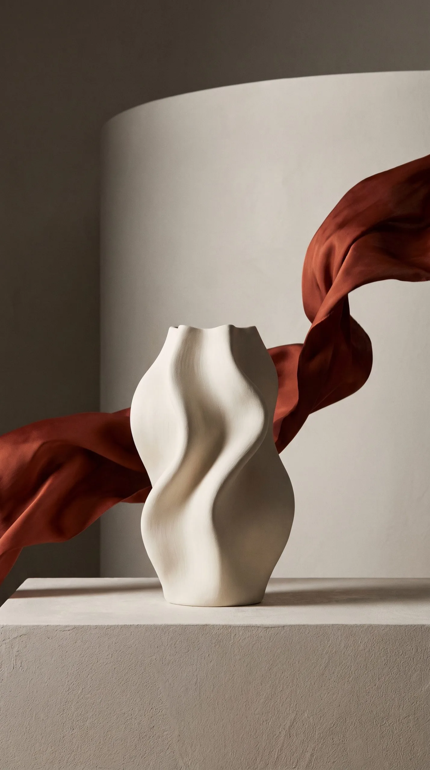Floating fabric product effect around a stoneware homeware vase with a looping terracotta ribbon