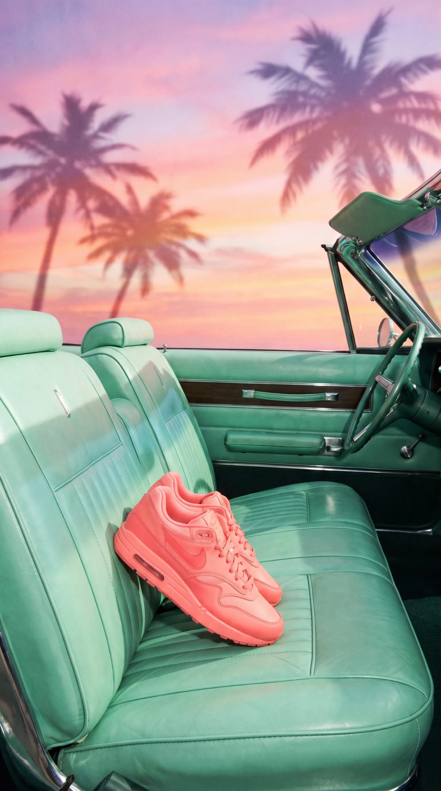 Miami vice product look of a coral lifestyle sneaker resting on a mint convertible car seat with chrome trim and peach sunset light